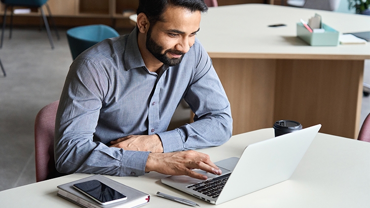 Businessman smiling using a laptop. 