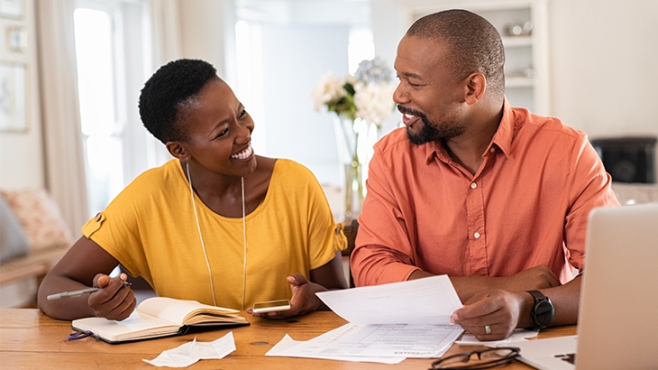 Couple smiling while doing paperwork.