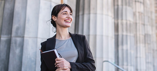 Businesswoman standing in front of government building columns 