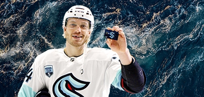 Hockey player holding a WaFd Seattle Kraken debit card.