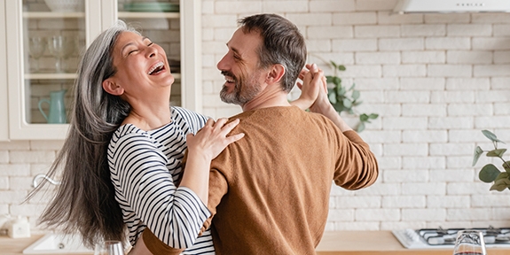 Happy couple dancing together in the kitchen