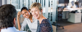 Women smiling in business meeting