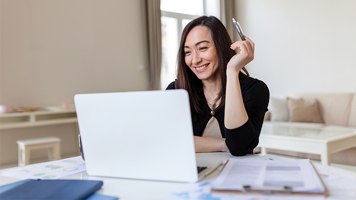 Smiling businesswoman working on laptop.