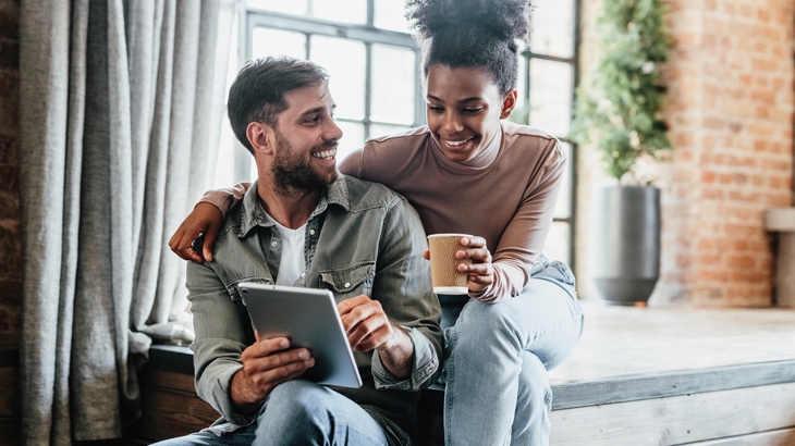 Couple in their new modern loft using tablet