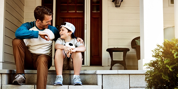 Father and his son laughing and talking on their porch at home