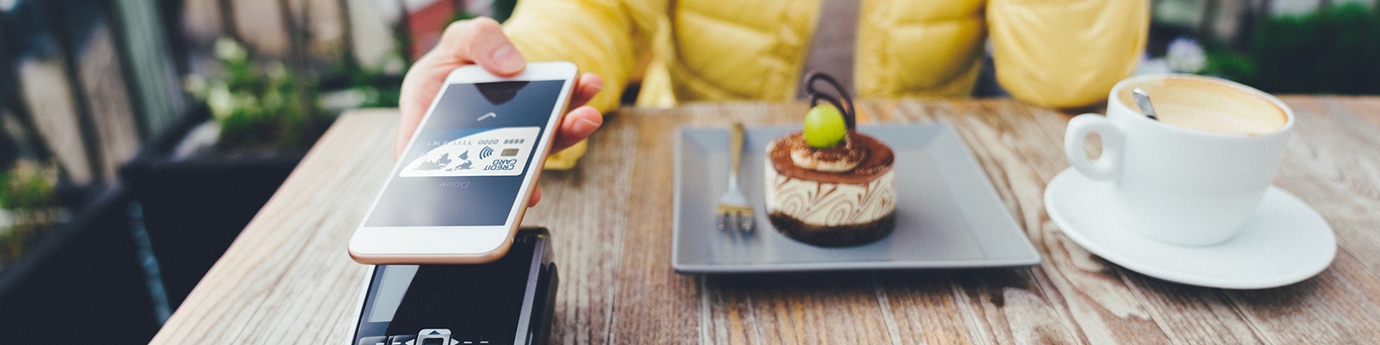 Woman paying for dessert with digital debit card mobile pay