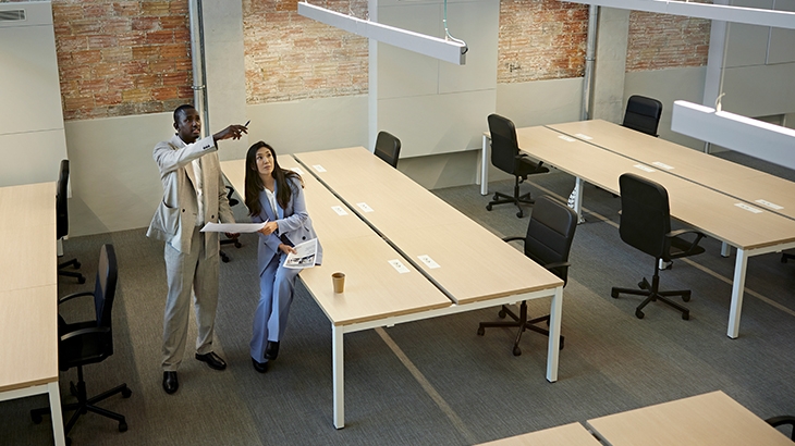 Real estate agent and businessman going over building plans.