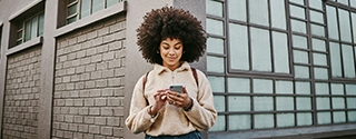 A young woman using WaFd Bank mobile app on her mobile phone.