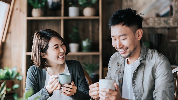 Happy young couple having a coffee date in cafe, drinking coffee and chatting.