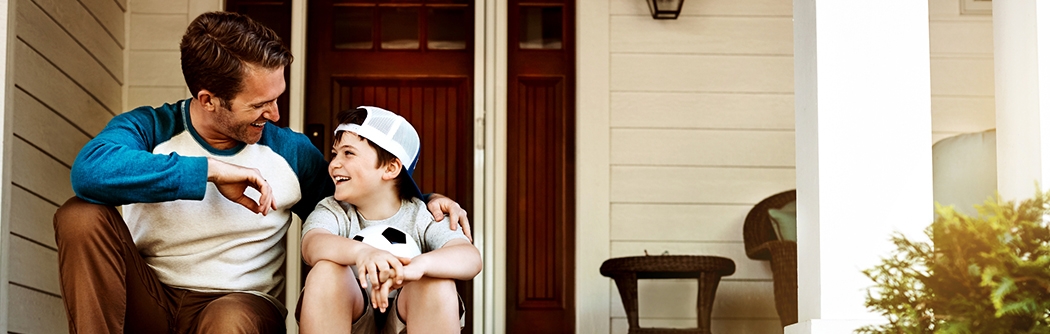 Father and his son laughing and talking on their porch at home