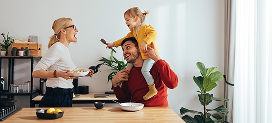 Family playing while cooking in the kitchen.