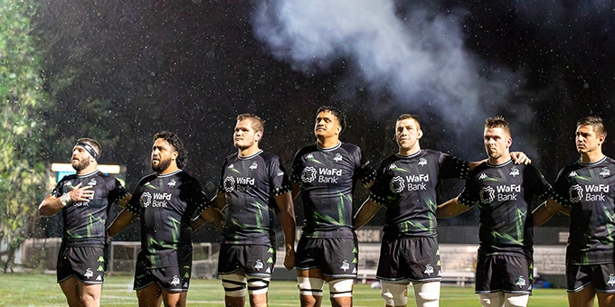 Seawolves team standing together on field.