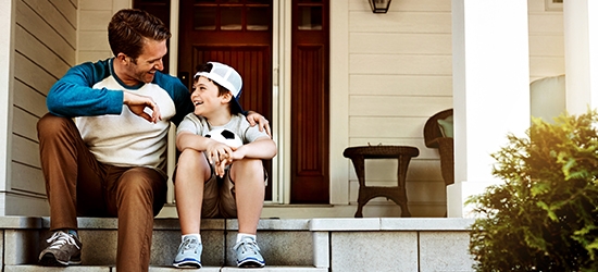 Father and his son laughing and talking on their porch at home