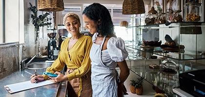 Business owner and employee in a shop reviewing financials.