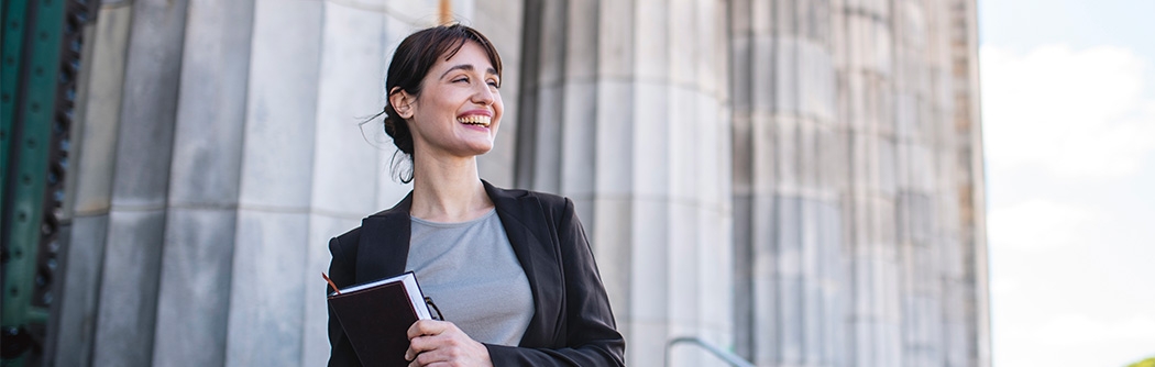 Businesswoman standing in front of government building columns 