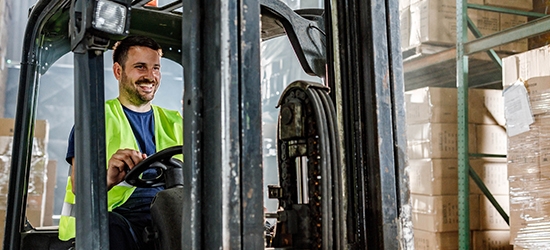 Warehouse worker driving a forklift in a storage room