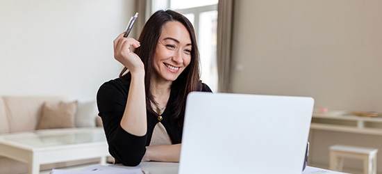 Smiling businesswoman working on laptop.