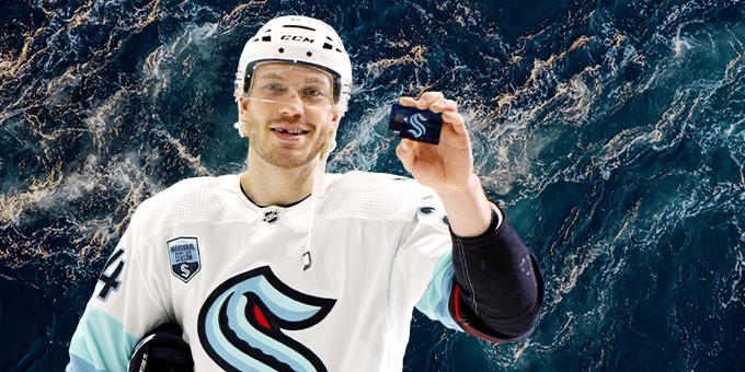 Hockey player holding a WaFd Seattle Kraken debit card.