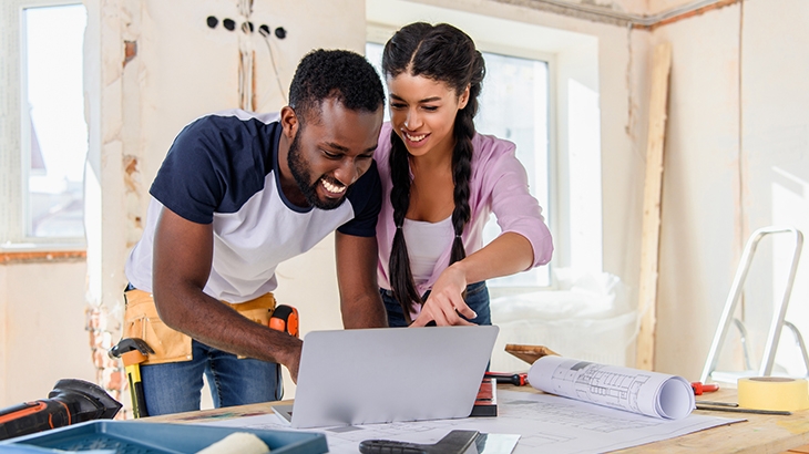 Couple looking at laptop during home renovation project