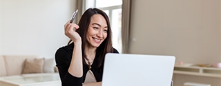 Smiling businesswoman working on laptop.