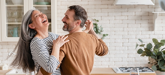 Happy couple dancing together in the kitchen