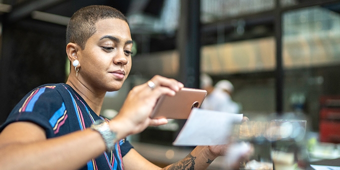 Woman depositing check with a mobile phone