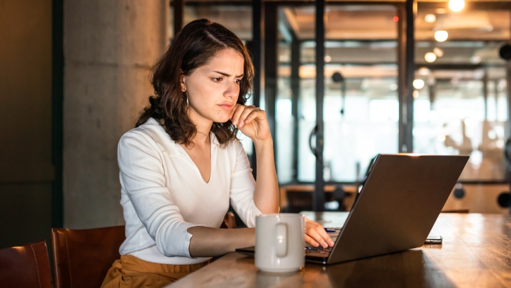 Woman having problems with her laptop with a confused and frustrated look.