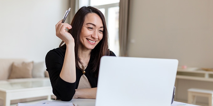 Smiling businesswoman working on laptop.