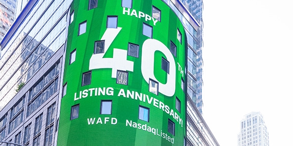 WaFd employees in Times Square NYC with WaFd Nasdaq sign