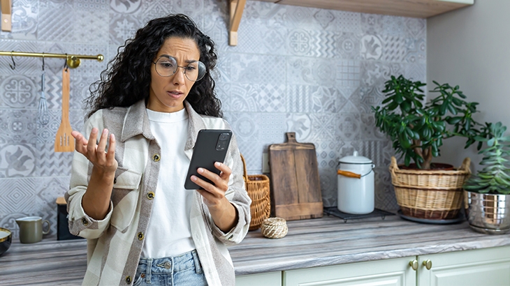 Woman looking at phone in frustration