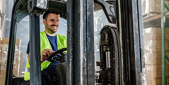 Warehouse worker driving a forklift in a storage room