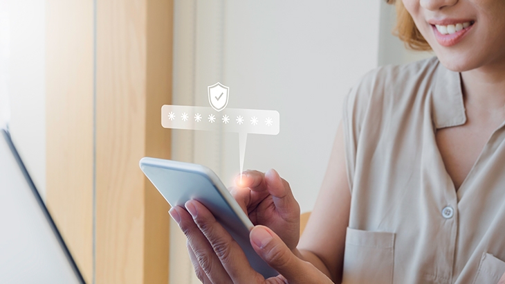 Woman entering secure password on smartphone, secure icon above.