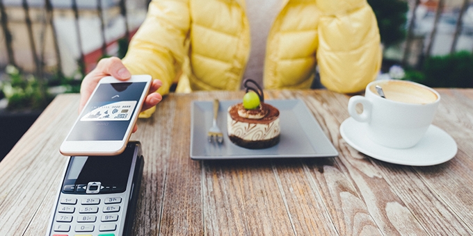 Woman paying for dessert with digital debit card mobile pay