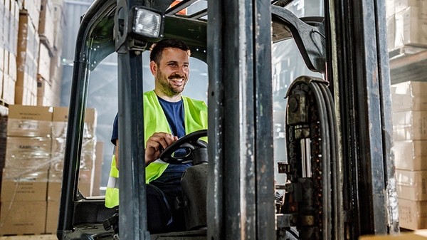 Warehouse worker driving a forklift in a storage room