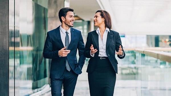 Two business people walking and talking in an office building