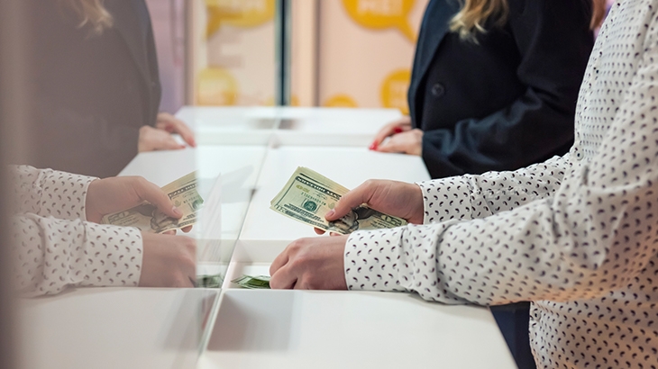 Depositing cash at bank counter.