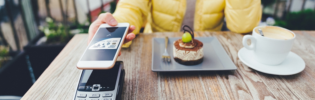 Woman paying for dessert with digital debit card mobile pay